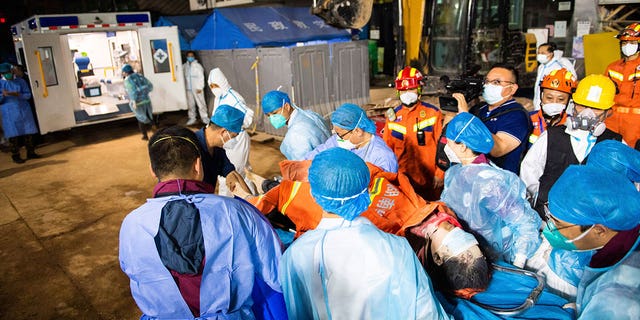 In this photo released by Xinhua News Agency, medical workers evacuate the 10th survivor pulled alive after being trapped 132 hours from the debris of a self-built residential structure that collapsed in Changsha in central China's Hunan Province on Thursday May 5, 2022. Rescuers in central China have pulled the woman alive from the rubble of a building that partially collapsed almost six days earlier, state media reported Thursday. (Chen Sihan/Xinhua via AP)