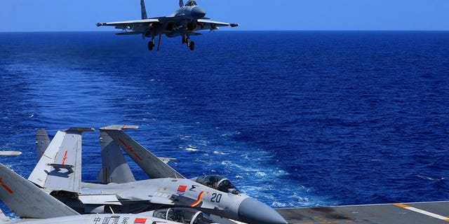 In this photo released Dec. 31, 2021, by Xinhua News Agency, an undated photo shows a carrier-based J-15 fighter jet preparing to land on the Chinese navy's Liaoning aircraft-carrier during open-sea combat training. China is holding military exercises in the disputed South China Sea coinciding with U.S. President Joe Biden's visits to South Korea and Japan that are largely focused on countering the perceived threat from China. (Hu Shanmin/Xinhua via G3 Box News)
