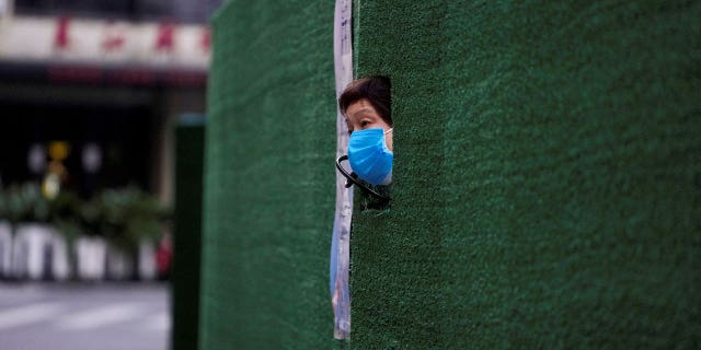 A resident looks out through a gap in the barrier at a residential area during lockdown amid the COVID-19 pandemic in Shanghai, China, May 6, 2022. 