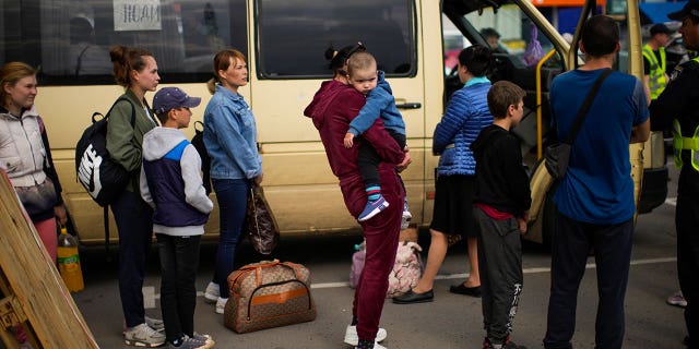 People wait to be processed upon their arrival at a reception center for displaced people in Zaporizhzhia, Ukraine, Monday, May 2, 2022. Thousands of Ukrainian continue to leave Russian occupied areas. (AP Photo/Francisco Seco)