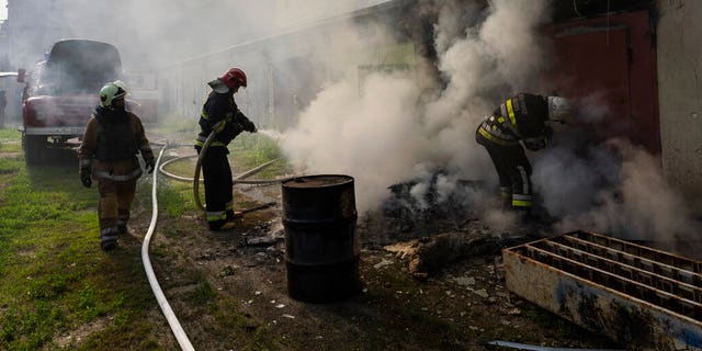Des pompiers ukrainiens tentent d'éteindre un incendie dans un entrepôt après une frappe russe à Kharkiv, dans l'est de l'Ukraine, le lundi 30 mai 2022. 