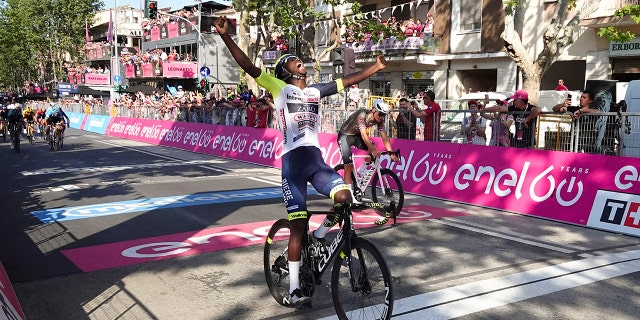 Eritrea's Biniam Girmay celebrates as he crosses the finish line Tuesday, May 17, 2022.