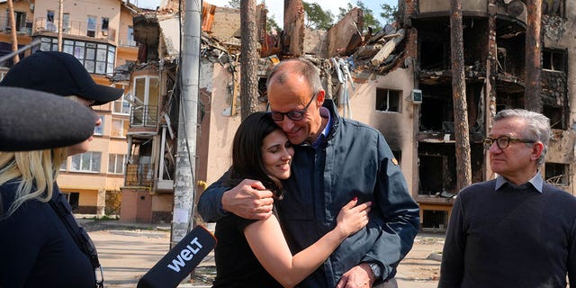 The Chairman of the German Christian Democratic Party (CDU) Friedrich Merz, center right, hugs with Halyna Yanchenko, a member of the Servant of the People political party, in Irpin, Ukraine, Tuesday, May 3, 2022. (AP Photo/Efrem Lukatsky)