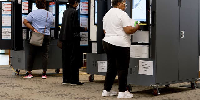 亚特兰大, 乔治亚州 - 可能 24: People use voting machines to fill out their ballots as they vote in the Georgia primary at the Metropolitan Library on May 24, 2022 在亚特兰大, 佐治亚州.