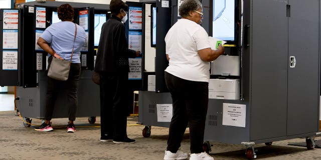 People fill out ballots using a voting machine during the Georgia primary election at the Metropolitan Library in Atlanta on May 24, 2022.