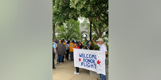 Viewers with signs cheering veterans on.