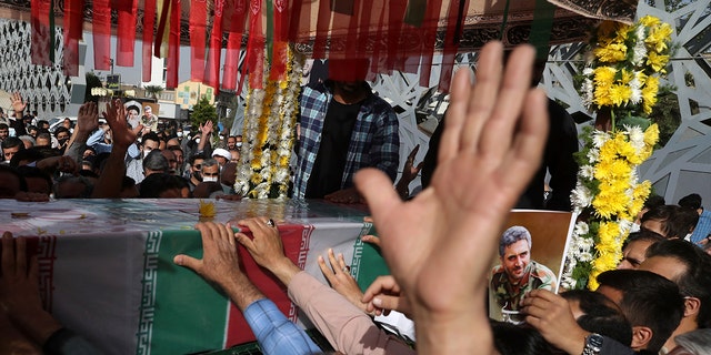 People mourn next to the flag-draped coffin of Iran's Revolutionary Guard Col. Hassan Sayyad Khodaei, who was killed, at his funeral in Tehran, Iran, May 24, 2022. 