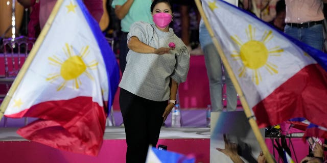 Vice President Leni Robredo greets supporters as a Philippine flag is waved during a campaign rally that coincides with her birthday in Pasay City, Philippines, on April 24, 2022.