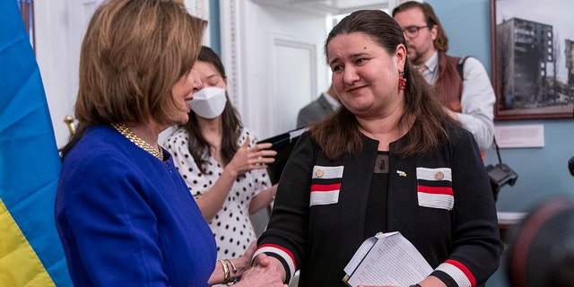 Speaker of the House Nancy Pelosi of Calif., left, shakes hands with Ukrainian Ambassador Oksana Markarova, during an event unveiling a photography exhibit about the war in Ukraine, Thursday, April 28, 2022, at the Capitol in Washington. 