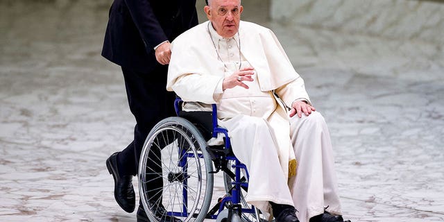 Pope Francis arrives on a wheelchair to meet with participants in the plenary assembly of the International Union of Superiors General at the Vatican, Mei 5, 2022.