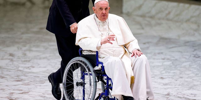 Pope Francis arrives on a wheelchair to meet with participants in the plenary assembly of the International Union of Superiors General at the Vatican, May 5, 2022.