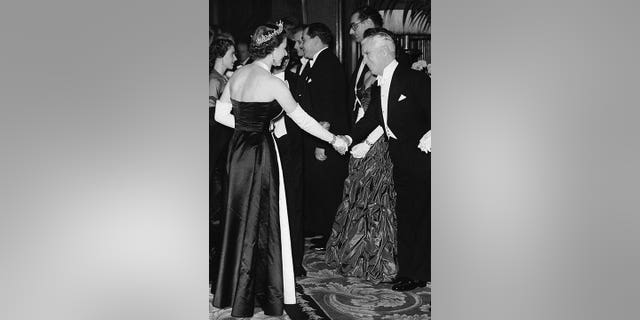 Queen Elizabeth II, at left, shakes hands with actor Charlie Chaplin at the Empire Theatre in London on Oct. 27, 1952, for the Royal Film Show, a benefit performance to aid the Cinematograph Trade Benevolent Fund. 