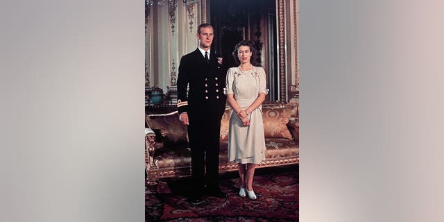 FILE - Britain's Princess Elizabeth in a light-colored dress with sleeves above the elbow and peekaboo low heels, appears with Lt. Philip Mountbatten for a photo in London in September 1947.