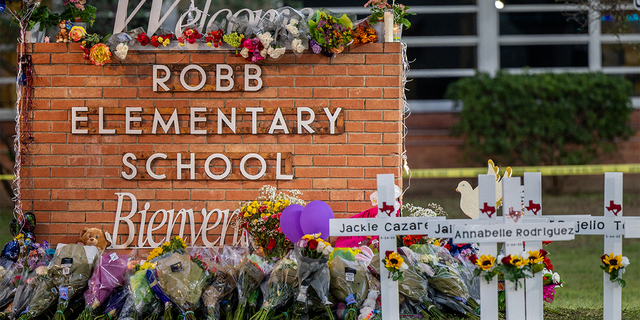 A memorial is seen surrounding the Robb Elementary School sign following the mass shooting at Robb Elementary School on May 26, 2022 in Uvalde, Texas. According to reports, 19 students and 2 adults were killed, with the gunman fatally shot by law enforcement.