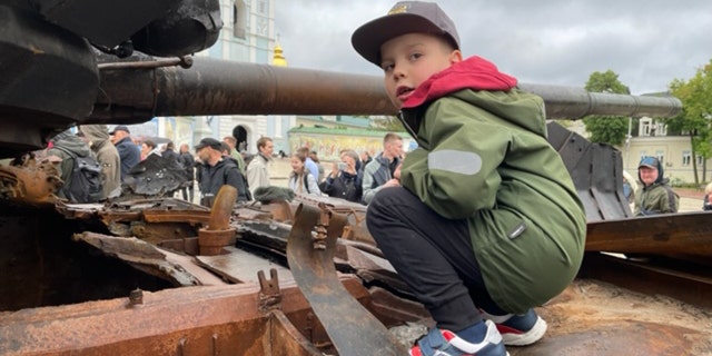 Children traumatized by war in Ukraine find mentors from unexpected places 3 A Ukrainian boy stands atop a depleted Russian military tank in Lyiv.