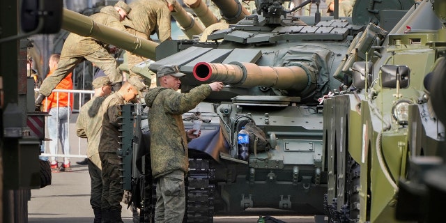 Russian soldiers tint their T-72 tanks on the eve of the Victory Day military parade 