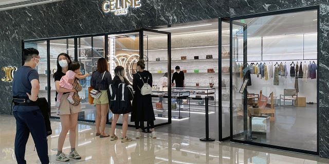 Shoppers wearing face masks line up outside a store of French luxury brand Celine at a reopened shopping mall amid the COVID-19 outbreak in Shanghai, China, May 29, 2022.