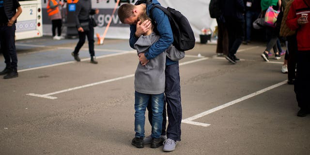 Andrii Fedorov hugs his son Makar as they reunite at a reception center for displaced people in Zaporizhzhia, Ukraine, Monday, May 2, 2022.