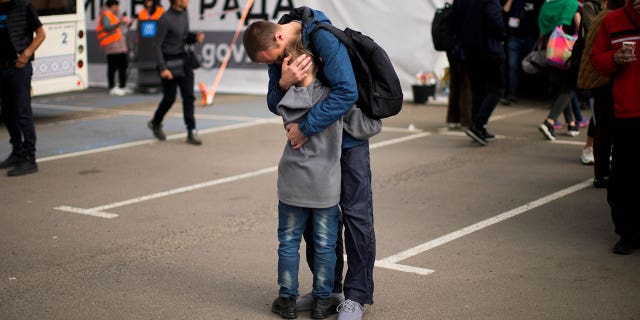 Andrii Fedorov hugs his son Makar as they reunite at a reception center for displaced people in Zaporizhzhia, Ukraine, Monday, May 2, 2022.