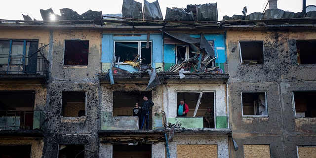 Local residents clean their apartments damaged by Russian shelling in Dobropillya, Donetsk region, eastern Ukraine, Saturday, April 30, 2022.