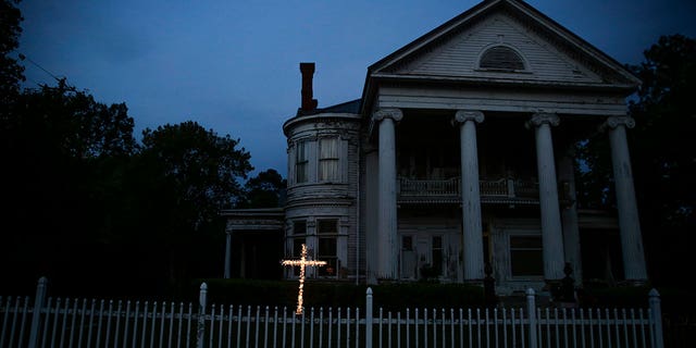 An illuminated cross stands in front of a home near downtown Dawson, Ga., April 17, 2020. 