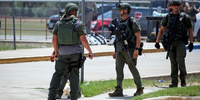 Law enforcement personnel stand outside Robb Elementary School following a shooting, Tuesday, May 24, 2022, in Uvalde, Texas. 