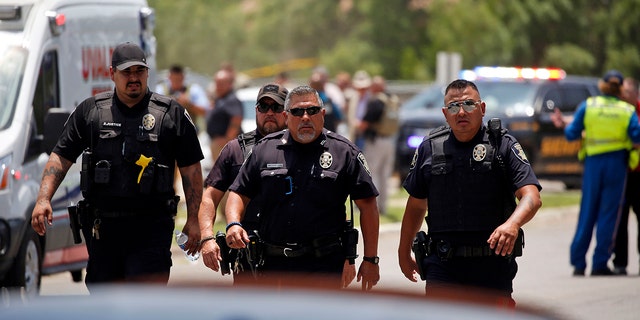 Police walk near Robb Elementary School following a shooting Tuesday, Mei 24, 2022, in Uvalde, Texas.