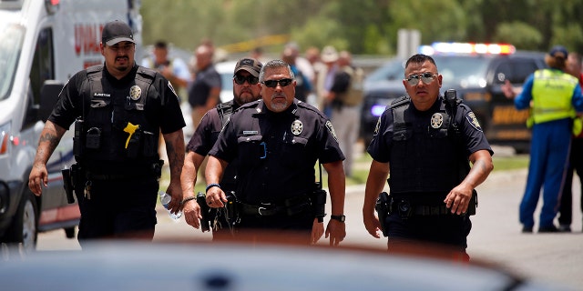 Police walk near Robb Elementary School following a shooting, Tuesday, May 24, 2022, in Uvalde, Texas.