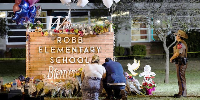 Stephanie and Michael Chavez of San Antonio pay their respects at a makeshift memorial outside Robb Elementary School on Wednesday, May 25.