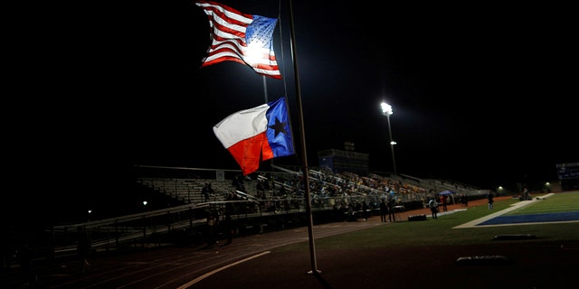 A U.S. flag and Texas state flag is seen at half-mast at La Vernia High School during a vigil in the memory of those killed in the Sutherland Springs shooting on November 7, 2017. 