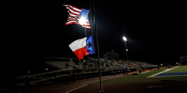 A U.S. flag and Texas state flag is seen at half-mast at La Vernia High School during a vigil in the memory of those killed in the Sutherland Springs shooting on November 7, 2017.