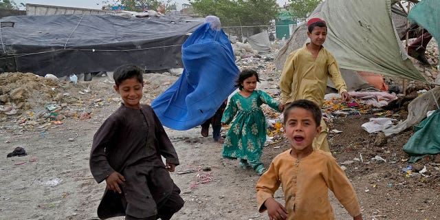 A woman wearing a burqa and her children in Kabul, Afghanistan, Sunday, May 8, 2022.