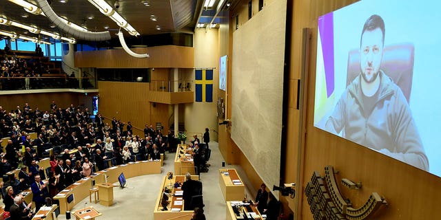 FILE - Ukraine's President Volodymyr Zelenskyy receives a standing ovation as he addresses Sweden's parliament via video link, in Stockholm, March 24, 2022. The question of whether to join NATO is coming to a head in Finland and Sweden, where Russia's invasion of Ukraine has shattered the long-held belief that remaining outside the military alliance was the best way to avoid trouble with their giant neighbor. (Paul Wennerholm/TT News Agency via AP, File)