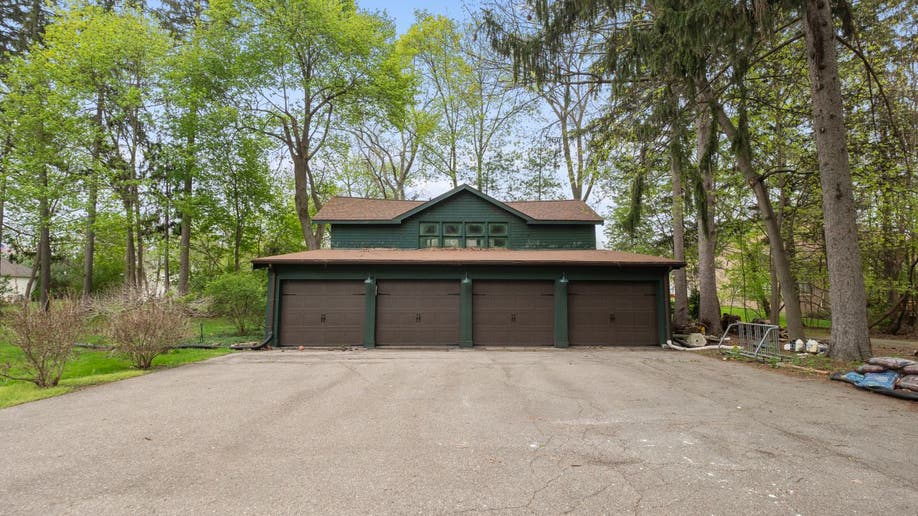 The Smurf House has a green garage with four brown doors and brown roofing.