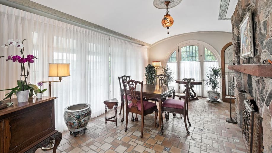 The Smurf house has a cream dining area or sunroom with arched and square windows.