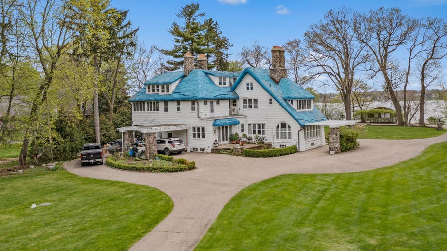 A far away view of the Smurf House, which has a long wraparound driveway.