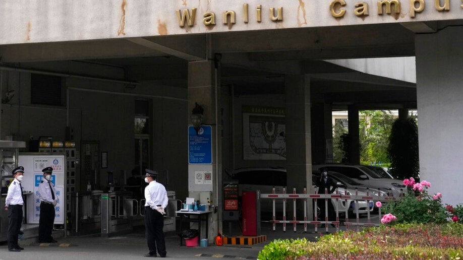 Security guards stand near an entrance to the Wanliu Campus of Beijing's Peking University