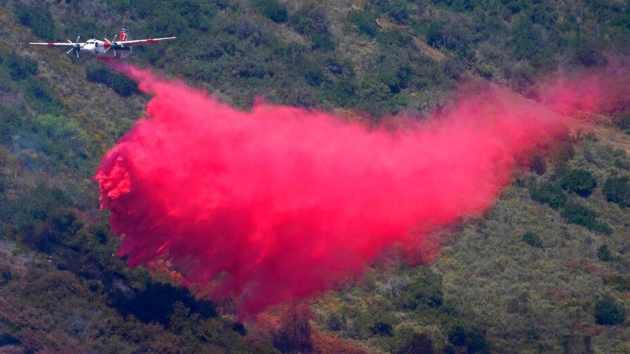 A plane drops retardant onto California's Coastal Fire