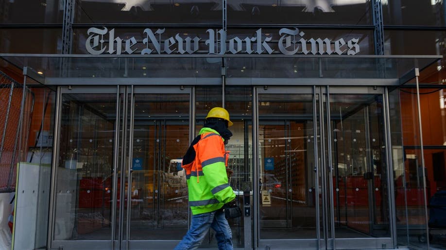 A construction worker walks past The New York Times Building in New York City on February 1, 2022.