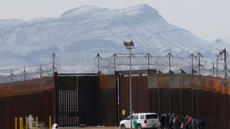 Border Patrol agents detain a group of migrants near the border wall, after they entered the United States from Ciudad Juarez, Chihuahua state, Mexico