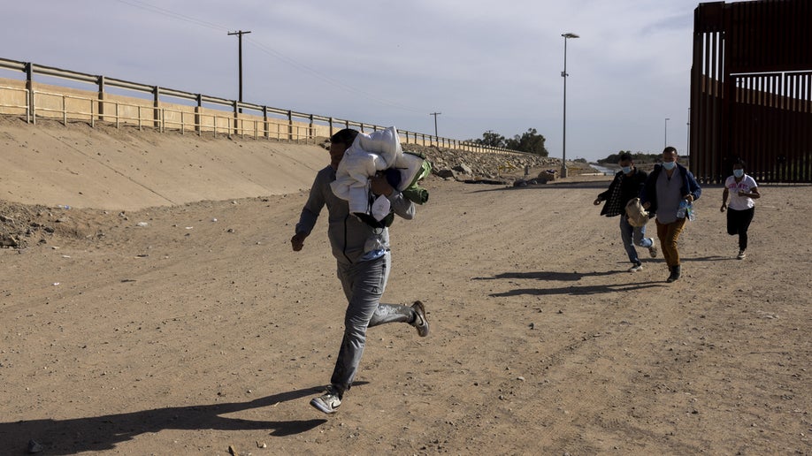 Migrants seeking asylum arrive after crossing the Mexico and U.S. border in Yuma, Arizona, U.S. on Tuesday, May 3, 2022. The U.S. immigration system would come under intense pressure if the end of a fast-track deportation policy triggers a surge of as many as 18,000 migrants at the southern border,