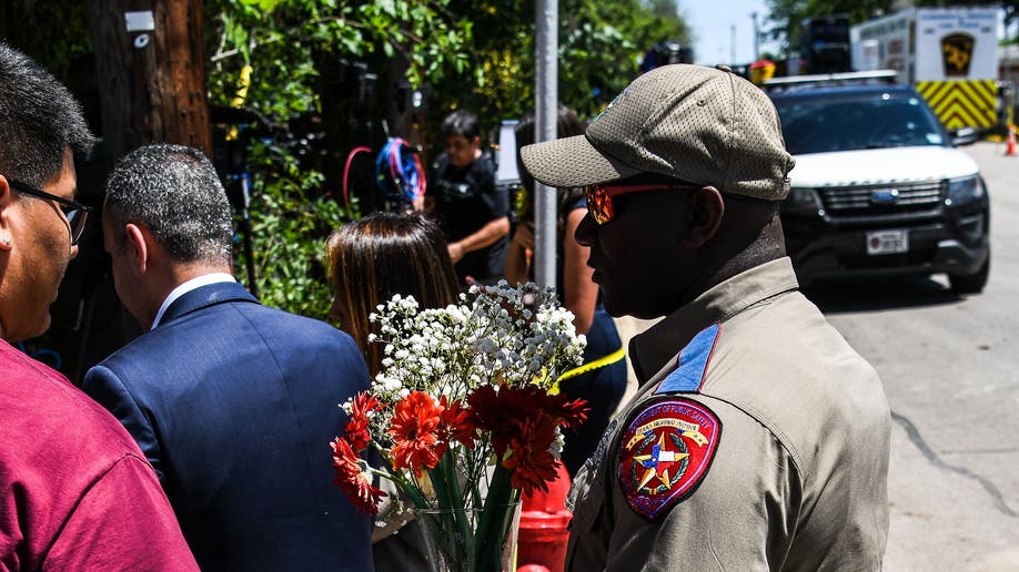 A police officer gives flowers to a grieving resident