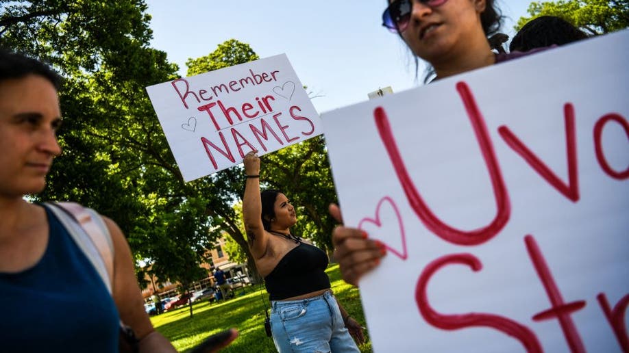 Residents hold placards as they mourn the victims of mass shooting in Texas