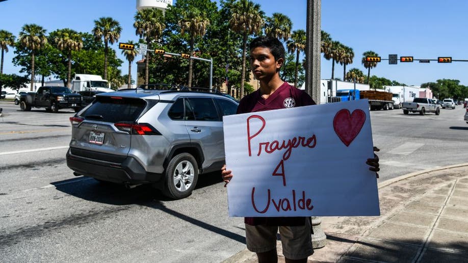 Resident holds sign saying 'Prayers 4 Uvalde'
