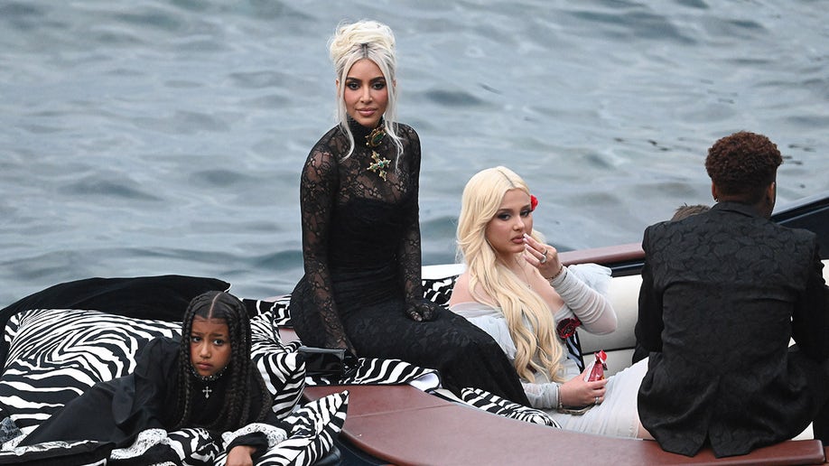 Kim Kardashian shows off platinum blonde hair while arriving to Kourtney's wedding with North West