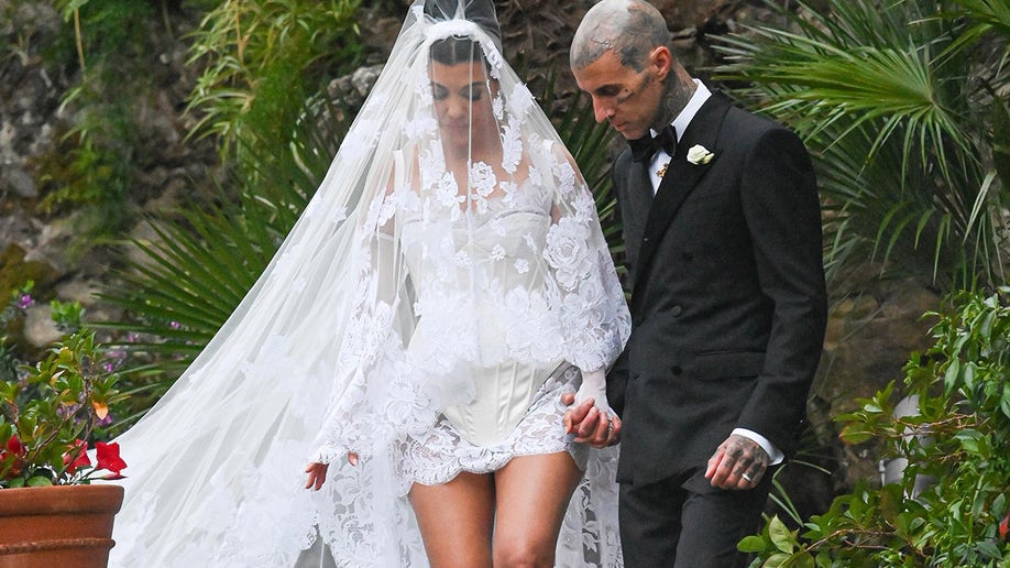 Kourtney Kardashian gets a helping hand from husband Travis Barker after wedding