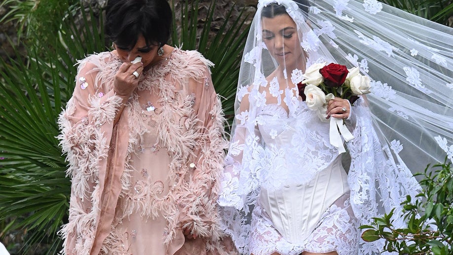 Kris Jenner and Kourtney Kardashian walk hand in hand at her wedding ceremony