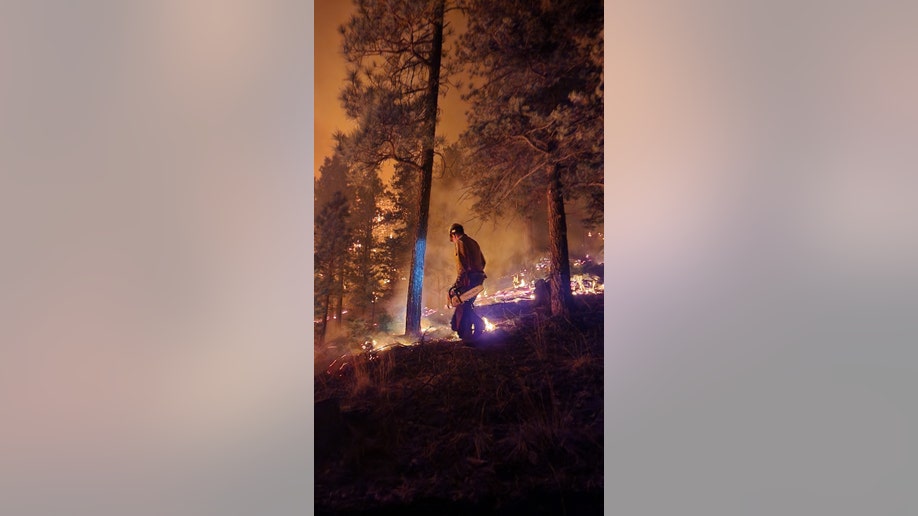 A firefighter works on New Mexico's Hermits Peak-Calf Canyon Fire Complex