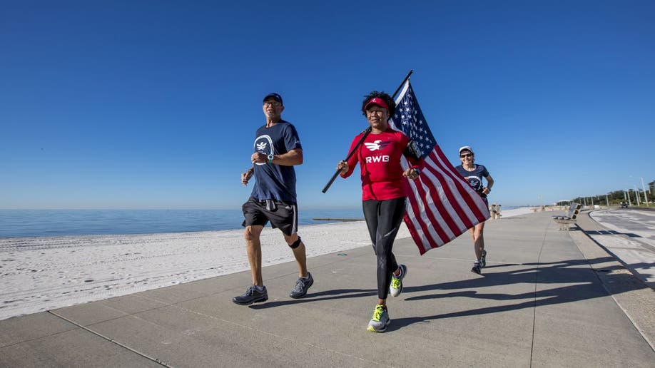 Three people run in the Old Glory Relay.