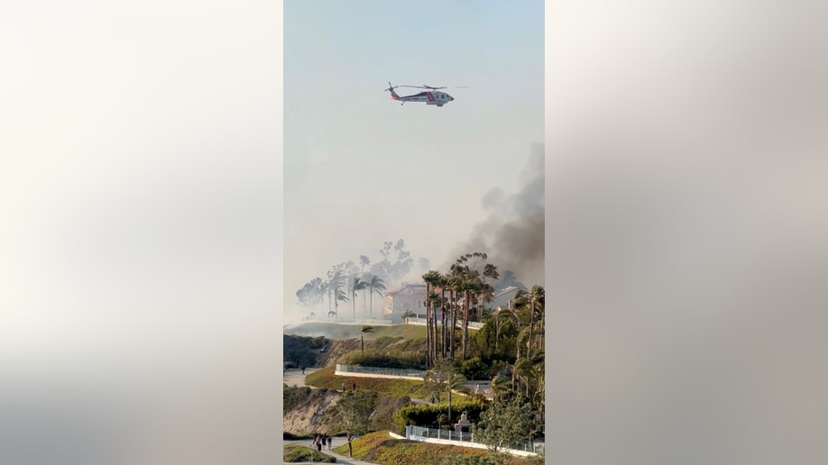 Helicopter flies over a California wildfire
